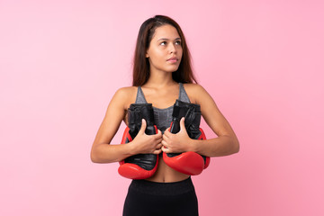 Young sport Brazilian girl over isolated pink background with boxing gloves