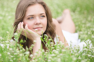 Beautiful young girl lying on the grass