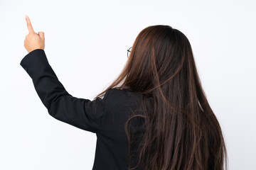 Young Brazilian girl with blazer over isolated white background pointing back with the index finger