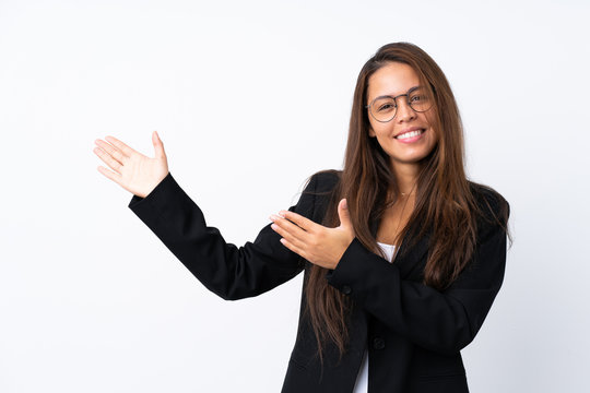 Young Brazilian girl with blazer over isolated white background extending hands to the side for inviting to come