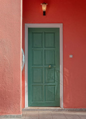 colorful house entrance green wooden door on redish wall, Athens Greece