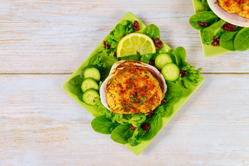 Stuffed clam with crabmeat and bread crumbs with salad and lemon. Seafood concept.