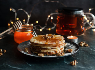 Dutch waffles with honey and nuts. Romantic composition with candles and other elements.