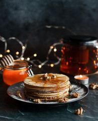 Dutch waffles with honey and nuts. Romantic composition with candles and other elements.