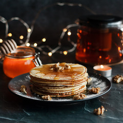 Dutch waffles with honey and nuts. Romantic composition with candles and other elements.