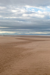 The vast empty beach at Formby in Merseyside, with an offshore windfarm visible in the sea