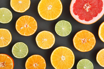 Different citrus and juicy slices on a colored background top view. Place to insert text.