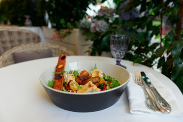 French appetizer of fried duck liver, camembert and lettuce served outdoors