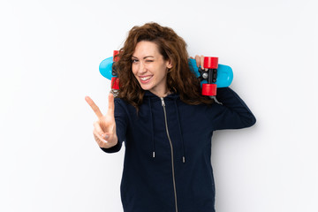 Young pretty woman over isolated background with skate and making victory gesture