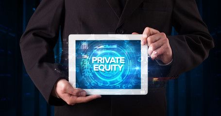 Young business person working on tablet and shows the inscription: PRIVATE EQUITY, business concept