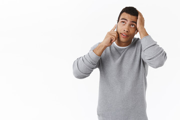 Busy guy troubled with phone call in bad time, holding hand on head, remember something as...
