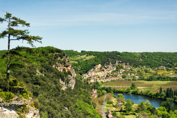 Fototapeta na wymiar View of one of most beautiful villages of France La Roque-Gageac, Dordogne, Aquitaine from Marqueyssac gardens. Countryside french landscape with Dordogne river, fields and hills. Travel destination.
