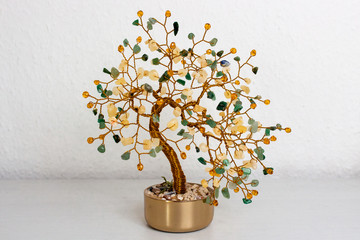 Decorative artificial and fake tree made of aluminum or copper wire with precious stone, crystal or gems as leafs for indoors decoration