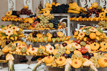 Catering table with different kind of fruits. Various sweet sliced fruit on a buffet table. Wedding day. Different fresh fruits on wedding buffet table