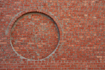 Red brick wall with a round niche 