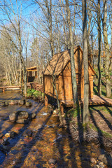 Log cabins at a stream in the woodlands