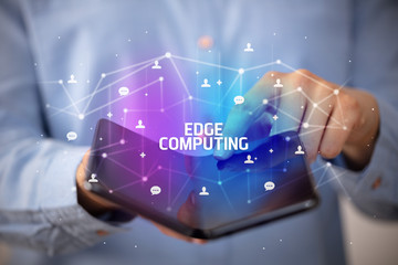 Businessman holding a foldable smartphone with EDGE COMPUTING inscription, new technology concept