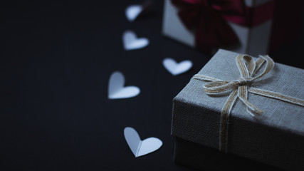 Gift boxes and hearts on a black background