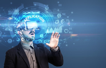 Businessman looking through Virtual Reality glasses with APPLICATION inscription, innovative technology concept