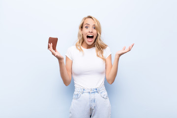 young blonde woman feeling happy, excited, surprised or shocked, smiling and astonished at...
