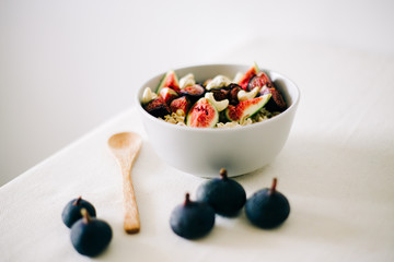 healthy Breakfast oatmeal with figs and cashews on a white table. vegan food