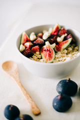 healthy Breakfast oatmeal with figs and cashews on a white table. vegan food