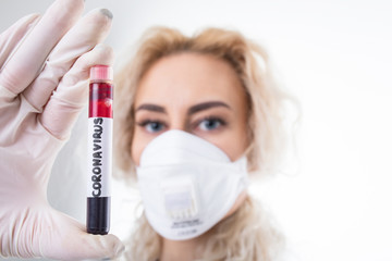 Girl doctor with a blood test tube of a new coronavirus. Epidemic of the disease
