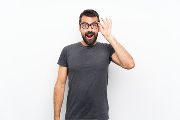 Fototapeta premium Young handsome man over isolated white background with glasses and surprised