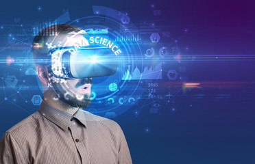 Businessman looking through Virtual Reality glasses with DATA SCIENCE inscription, innovative technology concept