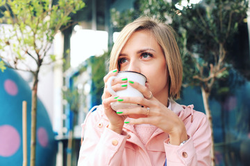 Young woman sitting at the street cafe , drinking coffee