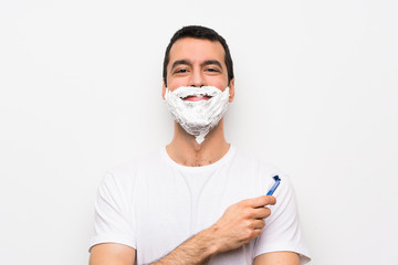 Man shaving his beard over isolated white background laughing