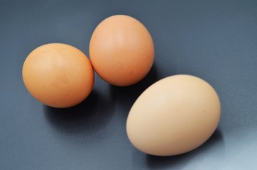 Three eggs on a black indoor background