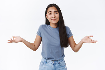 Girl saying sorry cant decide or think up solution, shrugging and spread hands sideways hopeless,...