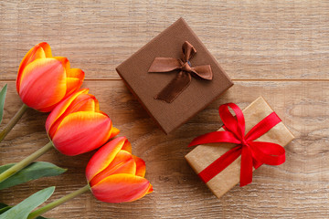 Gift boxes with red ribbons on wooden boards.