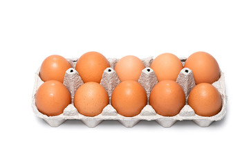 ten brown chicken eggs in a cardboard tray on a white background