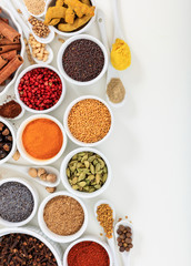 Spices and herbs flat lay, white background, top view.