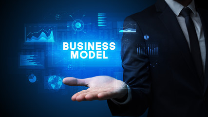 Hand of Businessman holding BUSINESS MODEL inscription, business success concept