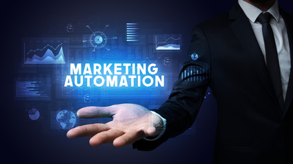Hand of Businessman holding MARKETING AUTOMATION inscription, business success concept
