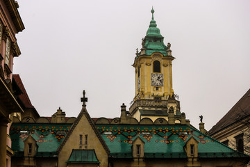 Fototapeta na wymiar Tejados verdes típicos de Bratislava y una torre con un reloj. 