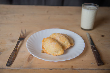 Panzerotti on a wooden table with milk