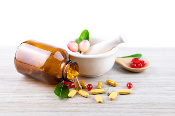 Herbal capsule from herbs nature for good health, vitamin, mineral supplement on wooden medical...