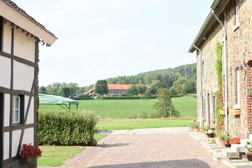 view on an old farm house between two typical buildings in Zuid-Limburg