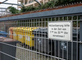 Secured garbage cans behind a fence at a residential building in Berlin, Germany