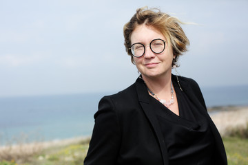 Portrait of a serious 40 year old woman walking along the beach