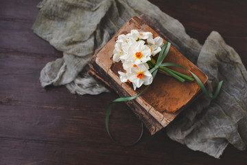 Small Bouquet of Paperwhite Nacissus tied with Green Ribbon on Vintage Books