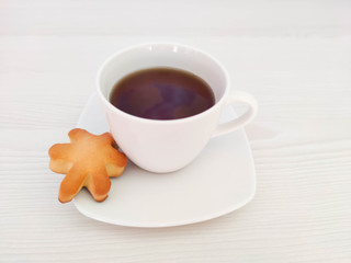 A white cup of tea or coffee and saucer on the wooden table with copy space. A photo for a café or restaurant menu or package backdrop.