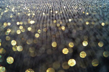 magical background with Golden sequins on a black fabric background macro photo