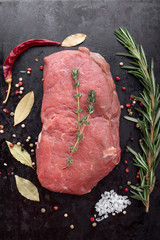 Raw steak with spices and cooking ingredients.