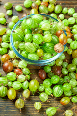 Ripe gooseberry in a glass plate, place for text, top view
