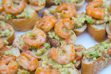 Sandwiches with chopped avocado and shrimp. Side view with selective focus. Home cooking concept